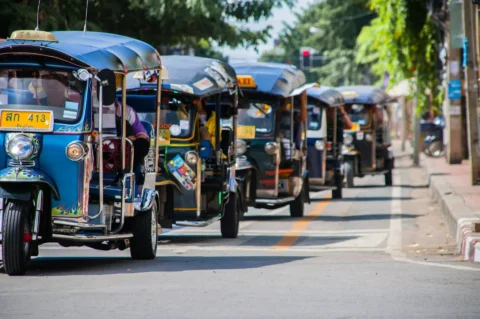Traditional tuk-tuks lined up on a street in Chiang Mai, Thailand